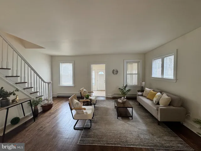 a living room with furniture wooden floor and a window