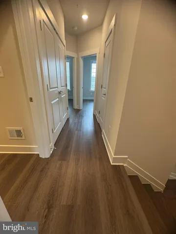 a view of a hallway with wooden floor