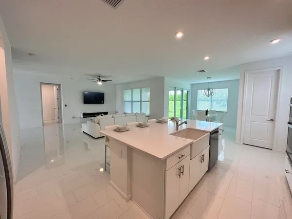 a view of dining room and kitchen with granite countertop a table chairs in it