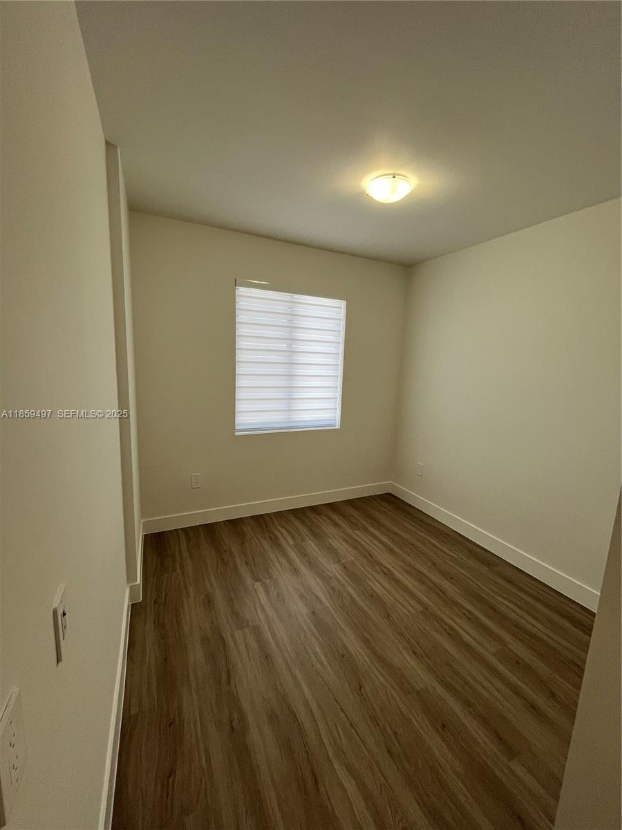 34515 Southwest 191st Court Homestead, FL 33034 - Photo 14 of 25 an empty room with wooden floor and windows