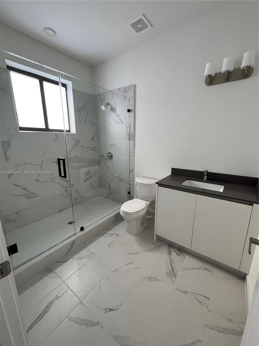 34515 Southwest 191st Court Homestead, FL 33034 - Photo 20 of 25 a bathroom with a granite countertop sink a toilet and shower