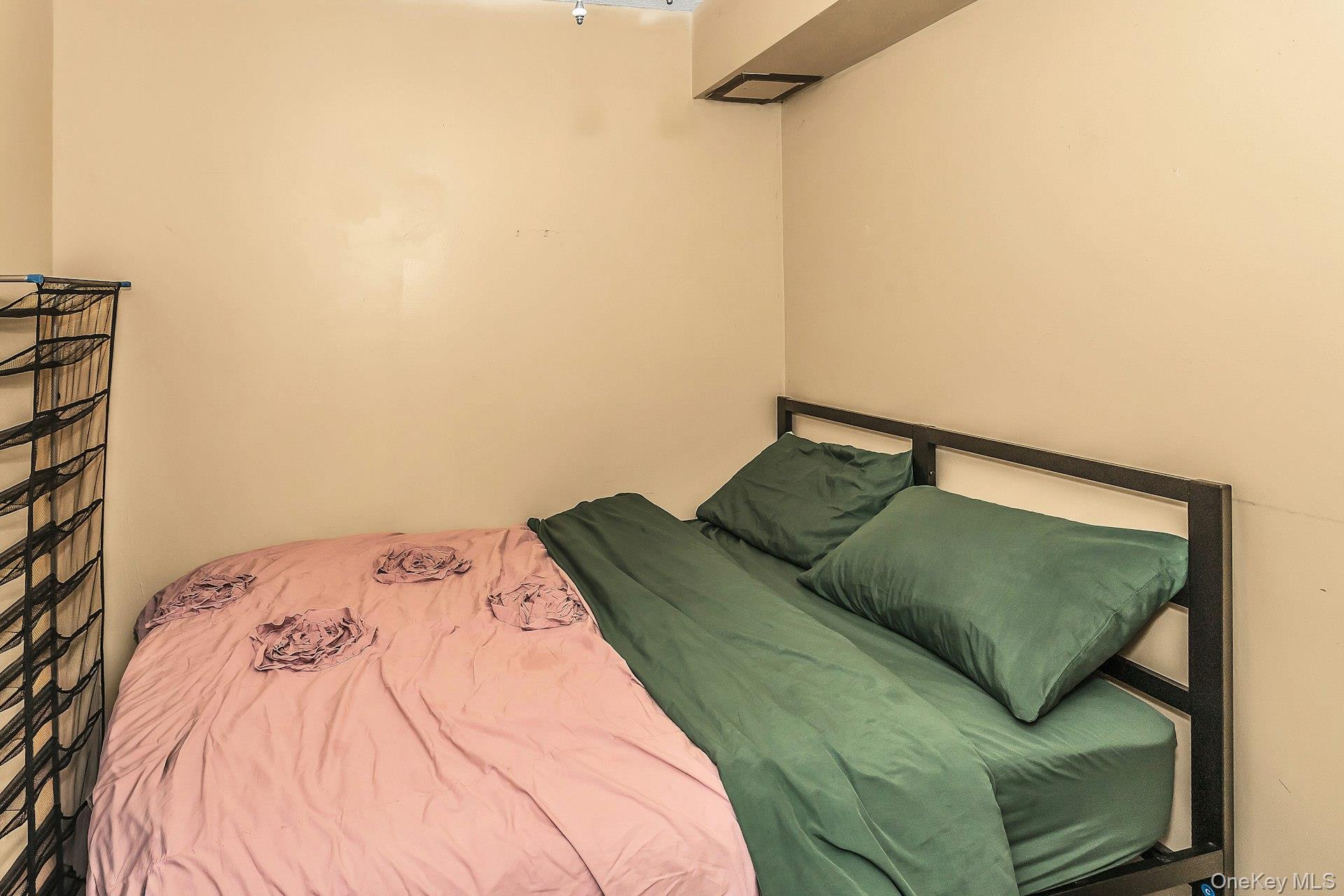 54-09 108th Street, Unit 1C Queens, NY 11368 - Photo 11 of 15 a bedroom with a bed and a window