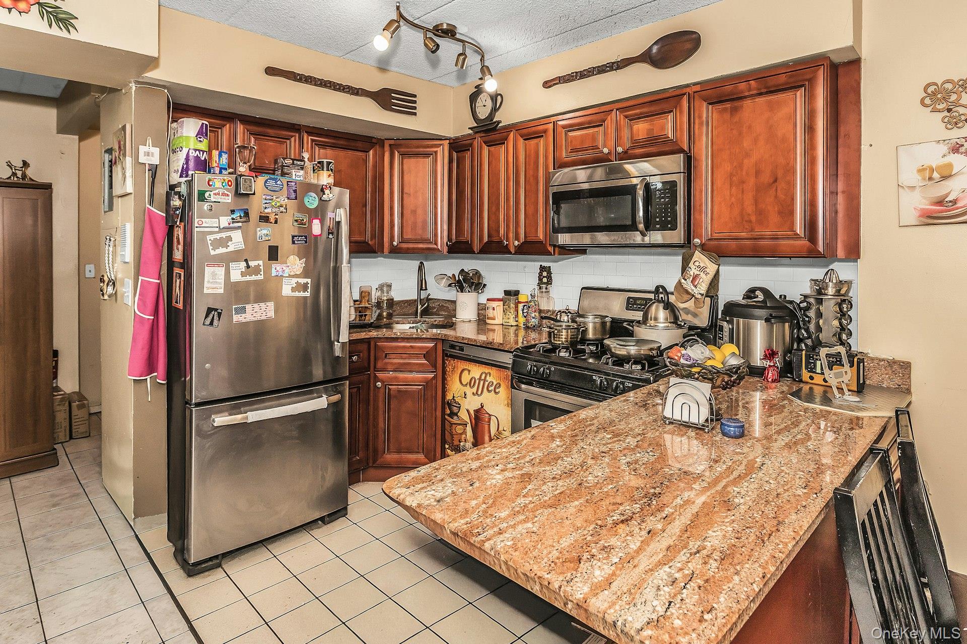 54-09 108th Street, Unit 1C Queens, NY 11368 - Photo 7 of 15 a kitchen with stainless steel appliances granite countertop a refrigerator a stove top oven a sink and dishwasher