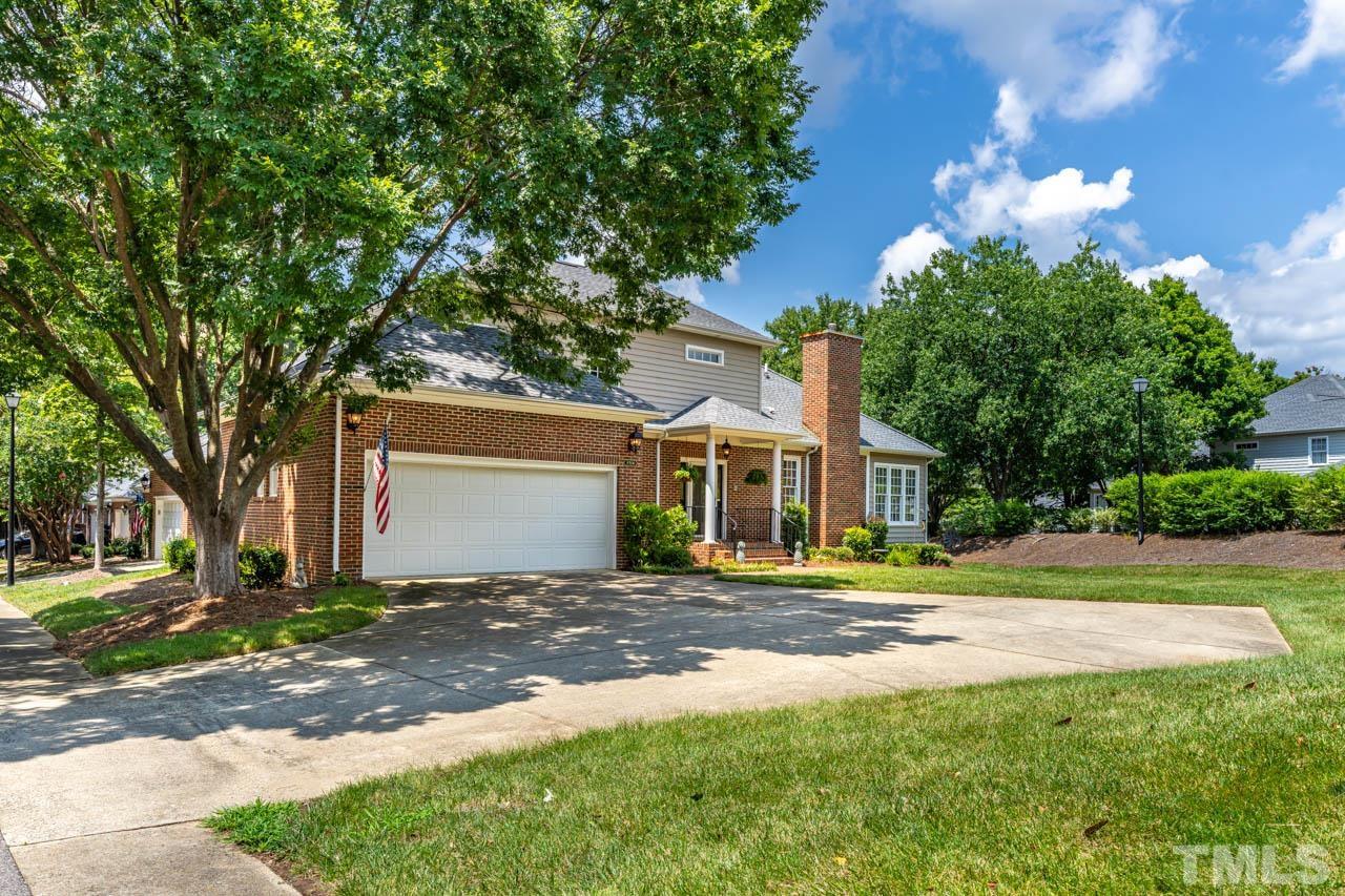 a front view of a house with a yard and trees