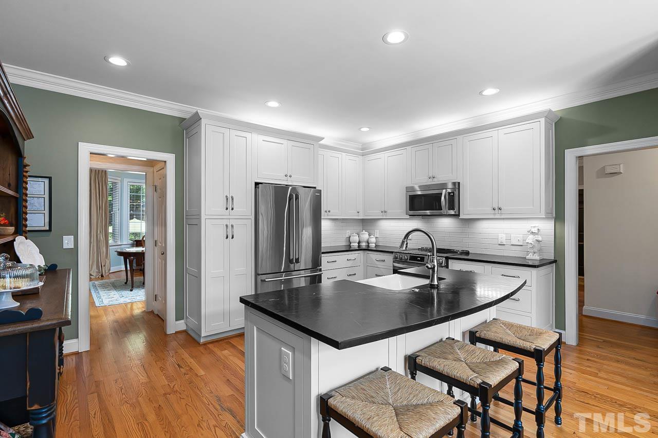 3500 Proprietor Way Raleigh, NC 27612 - Photo 20 of 47 a kitchen with kitchen island a refrigerator stove microwave and cabinets