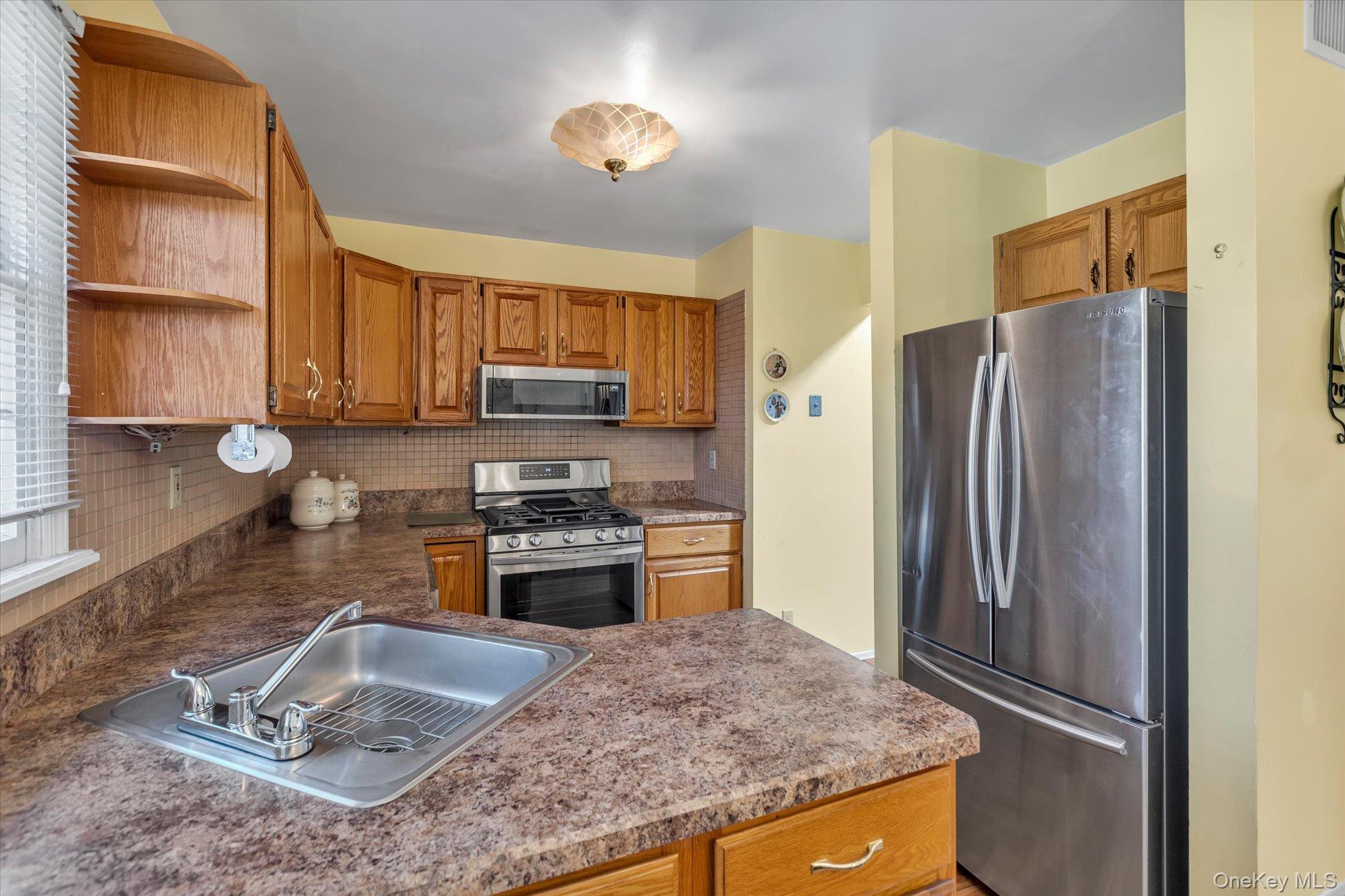 20 Primrose Lane North Babylon, NY 11703 - Photo 8 of 19 a kitchen with stainless steel appliances granite countertop a refrigerator stove and sink