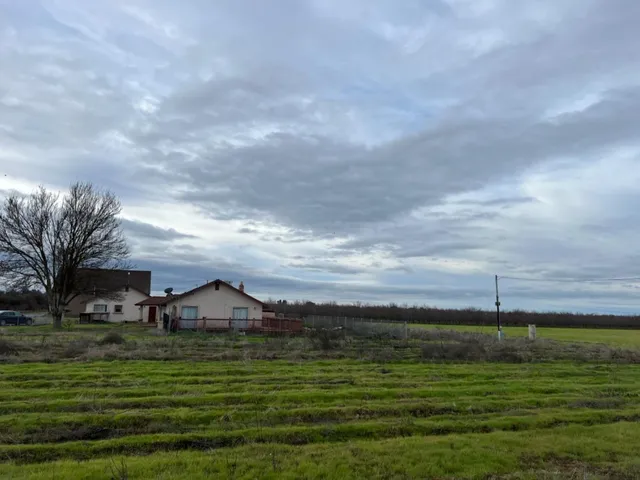 a view of a big yard with a house in the background