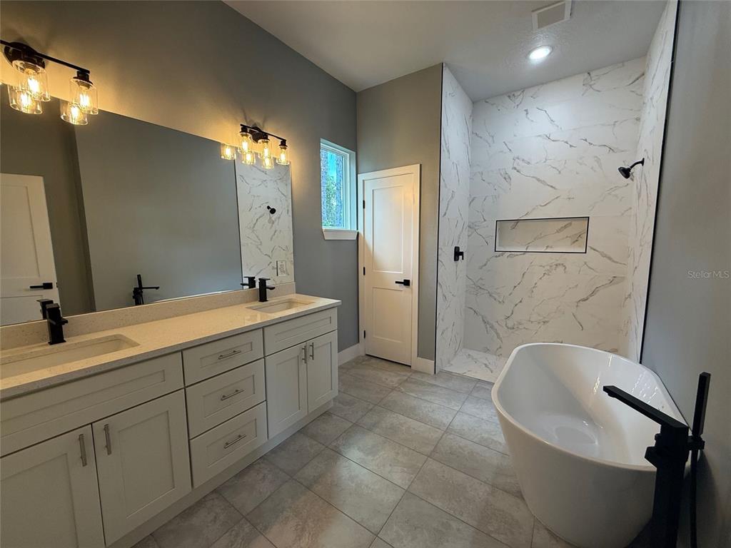 14919 Southwest 46th Circle Ocala, FL 34473 - Photo 20 of 22 a bathroom with a double vanity sink a toilet a mirror and shower