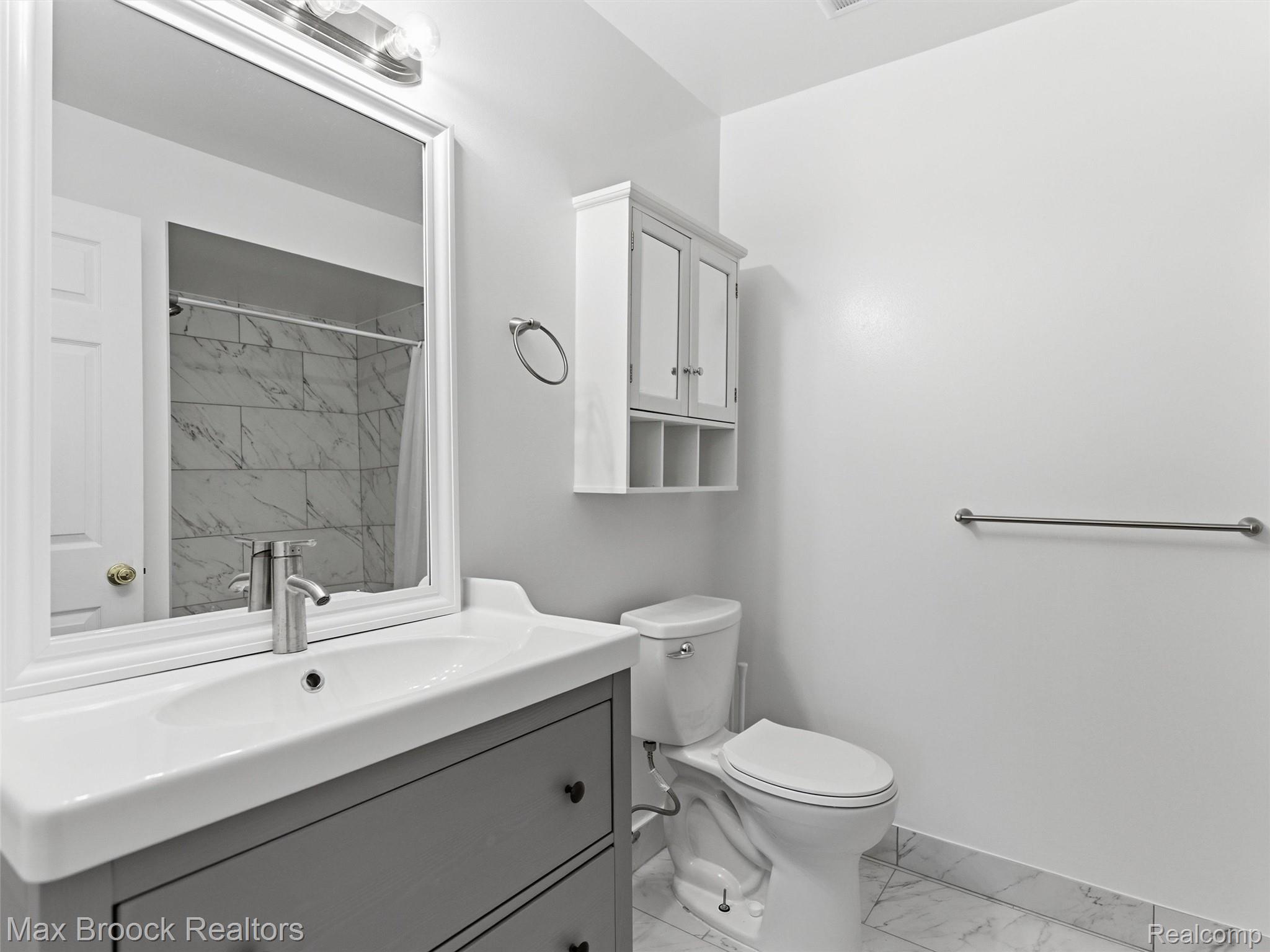 3562 Tremonte Circle Rochester, MI 48306 - Photo 18 of 33 Bathroom featuring a contemporary vanity with an integrated sink, brushed nickel faucet, and a framed mirror with overhead lighting