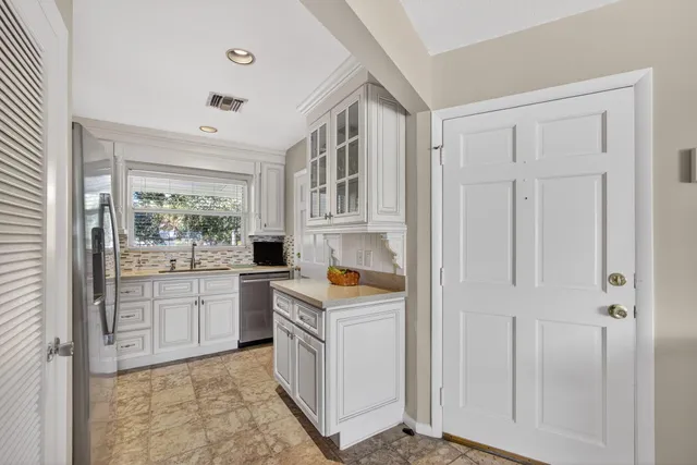 a room with white cabinets and white appliances