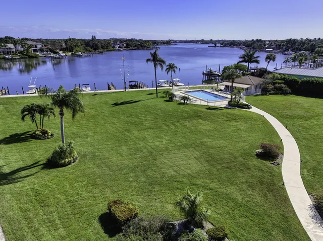 an aerial view of a house with a garden and lake view