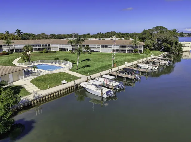 an aerial view of a house with swimming pool garden and lake view