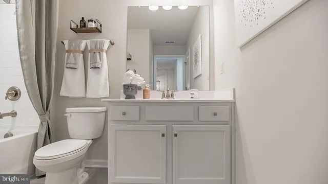 a bathroom with a sink vanity mirror and toilet