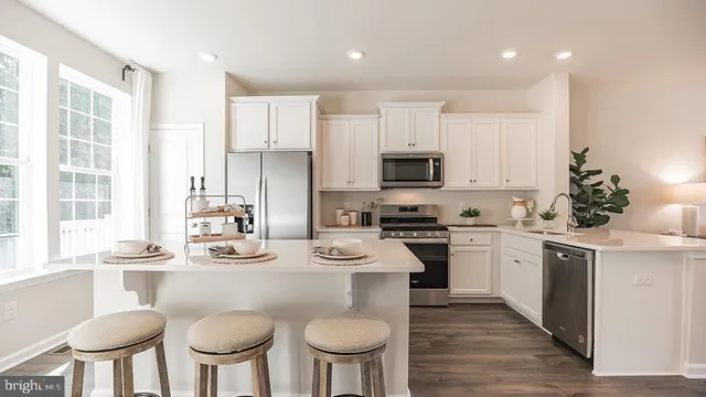 a kitchen with stainless steel appliances a dining table chairs microwave and stove