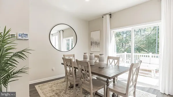 a dining room with furniture a rug and a floor to ceiling window