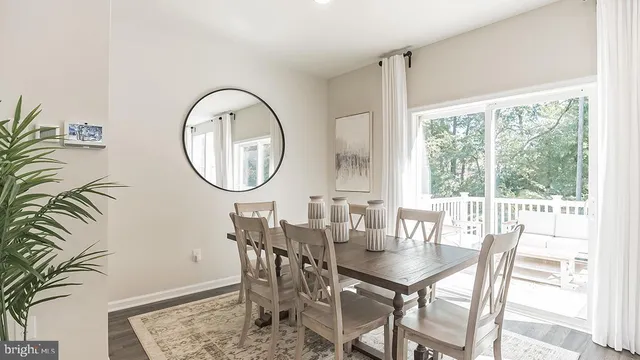 a dining room with furniture a rug and a floor to ceiling window