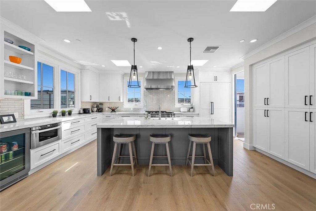 309 Crest Drive Manhattan Beach, CA 90266 - Photo 4 of 27 a kitchen with stainless steel appliances granite countertop a white cabinets and wooden floor