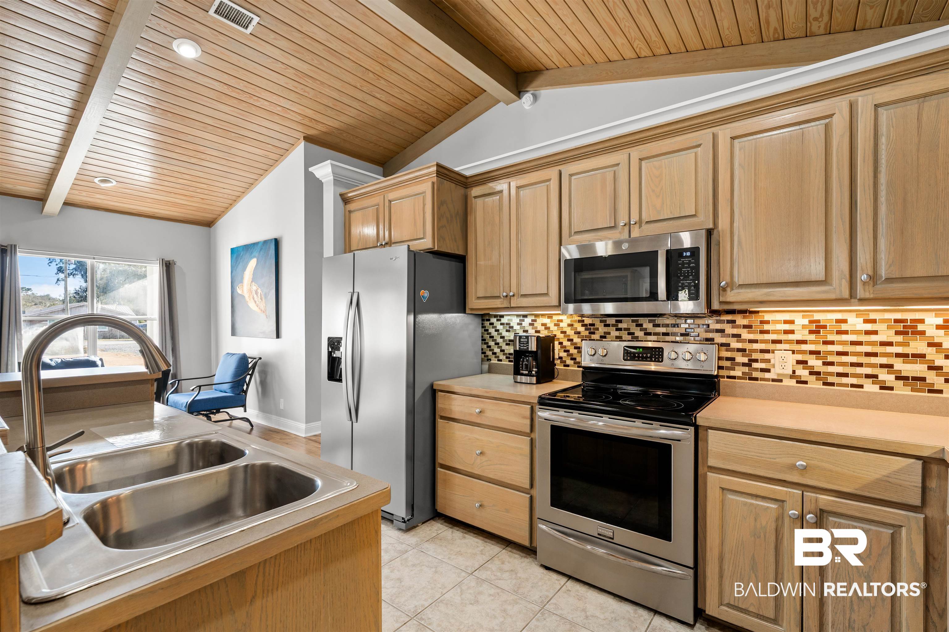 19079 Baldwin County Road 10 Foley, AL 36535 - Photo 7 of 37 Kitchen with stainless steel appliances, light countertops, a wooden ceiling with exposed beams, light tile patterned floors, and light wood finish cabinetry