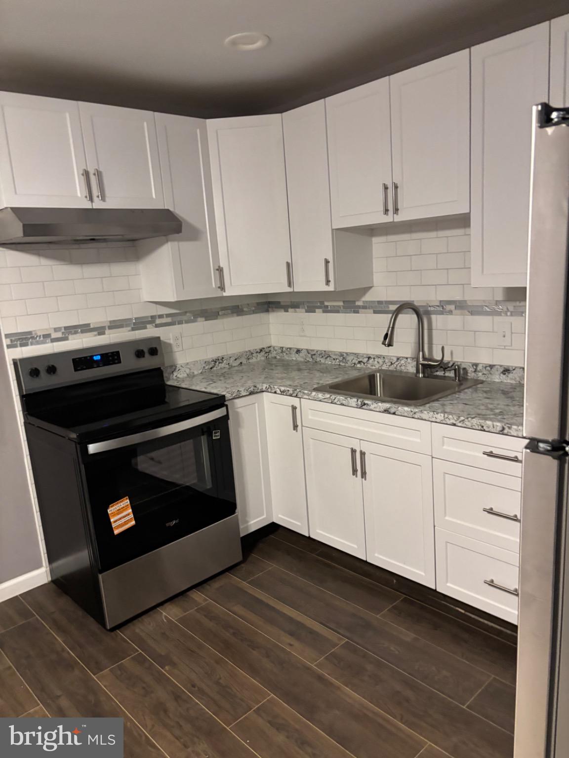 2113 Kennedy Street Philadelphia, PA 19124 - Photo 2 of 10 a kitchen with granite countertop white cabinets and white appliances