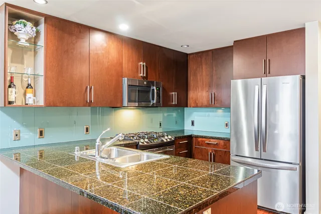 a kitchen with stainless steel appliances granite countertop a refrigerator sink and cabinets