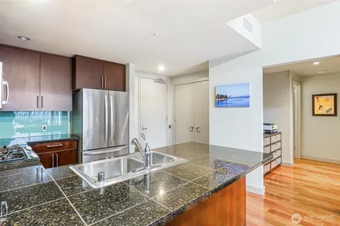 a kitchen with granite countertop a refrigerator and a sink