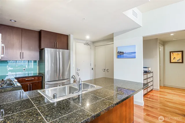a kitchen with granite countertop a refrigerator and a sink