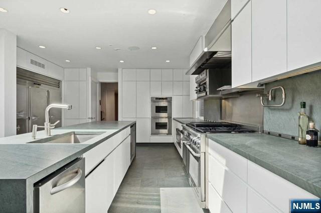 532 Winthrop Road Teaneck, NJ 07666 - Photo 5 of 42 a kitchen with stainless steel appliances granite countertop a sink and a stove