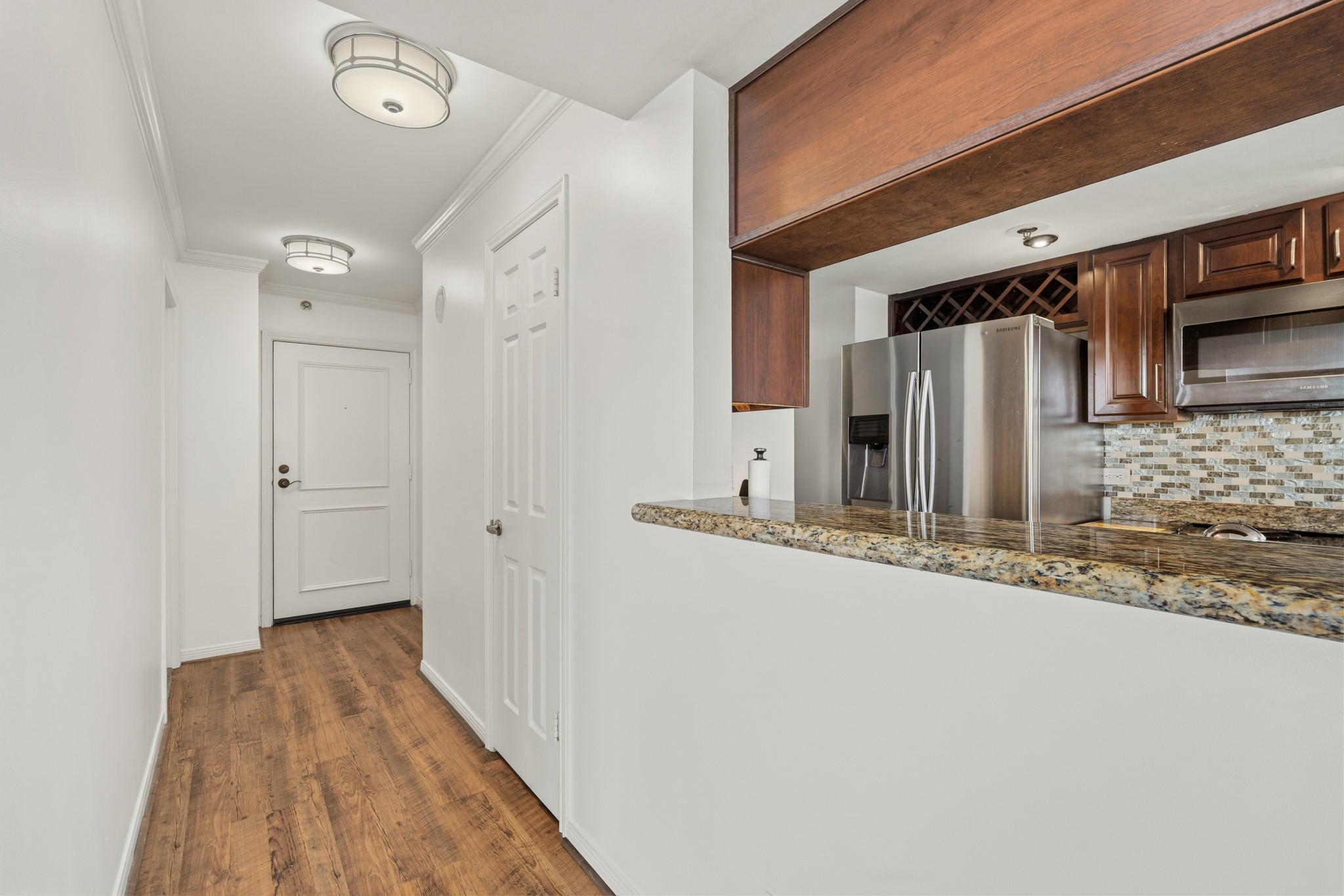 3525 Sage Road, Unit 1204 Houston, TX 77056 - Photo 10 of 25 Kitchen view featuring granite countertops and a pass-through opening to the living space.