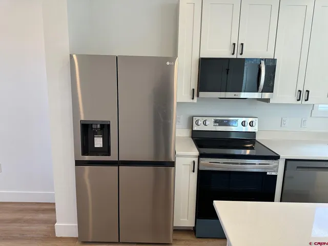 a kitchen with stainless steel appliances a stove a microwave and cabinets