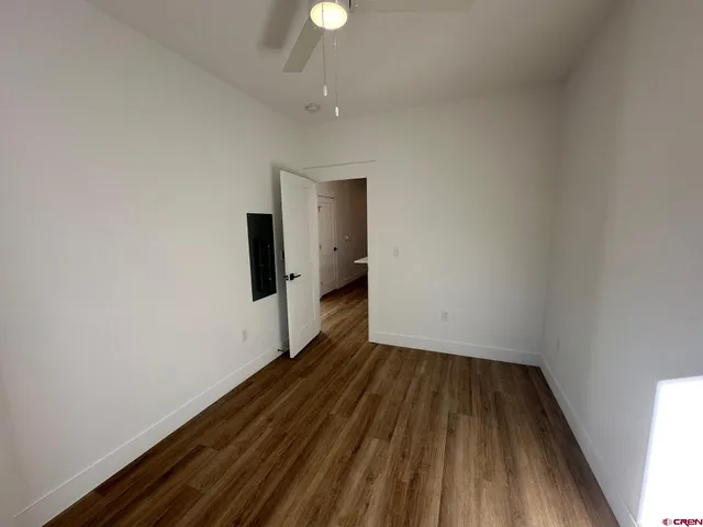 a view of an empty room with wooden floor