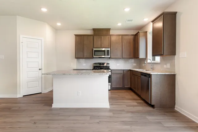 a kitchen with a sink cabinets and wooden floor