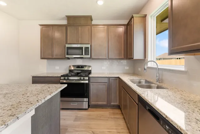 a kitchen with granite countertop a sink and stainless steel appliances
