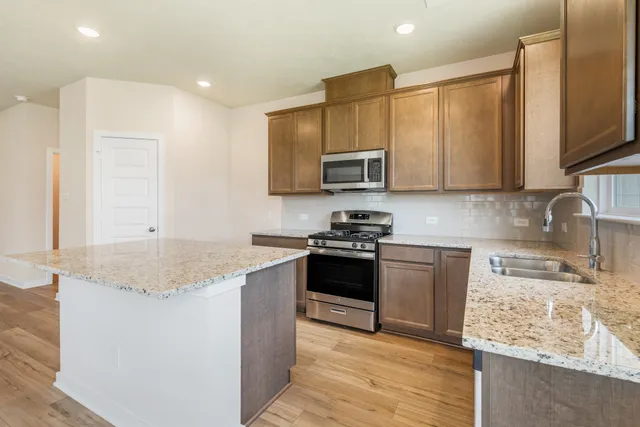 a kitchen with stainless steel appliances granite countertop a sink stove and microwave