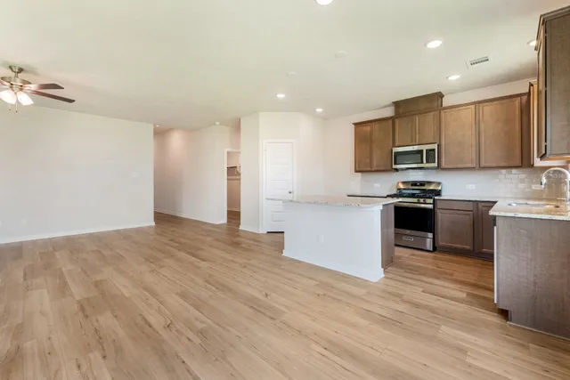 a kitchen with stainless steel appliances granite countertop a stove a sink and a refrigerator