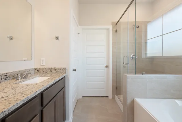 a bathroom with a granite countertop sink a mirror and a bathtub