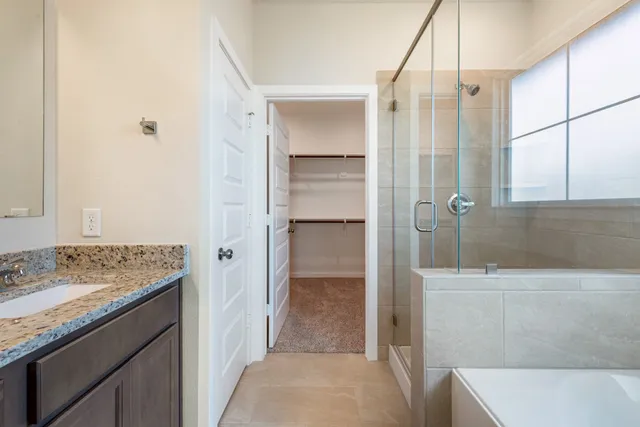a bathroom with a granite countertop sink and shower