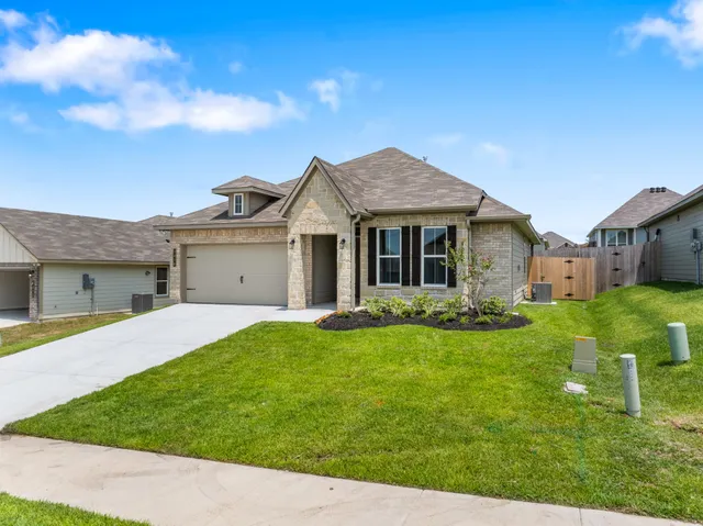 a front view of a house with a garden and yard