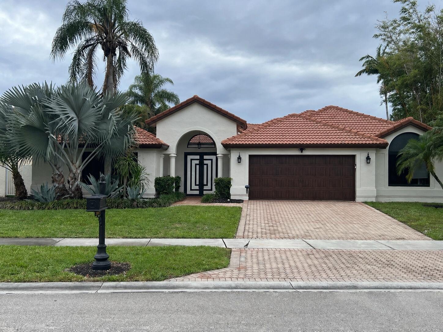 20077 Palm Island Drive Boca Raton, FL 33498 - Photo 1 of 47 a front view of a house with a yard and garage
