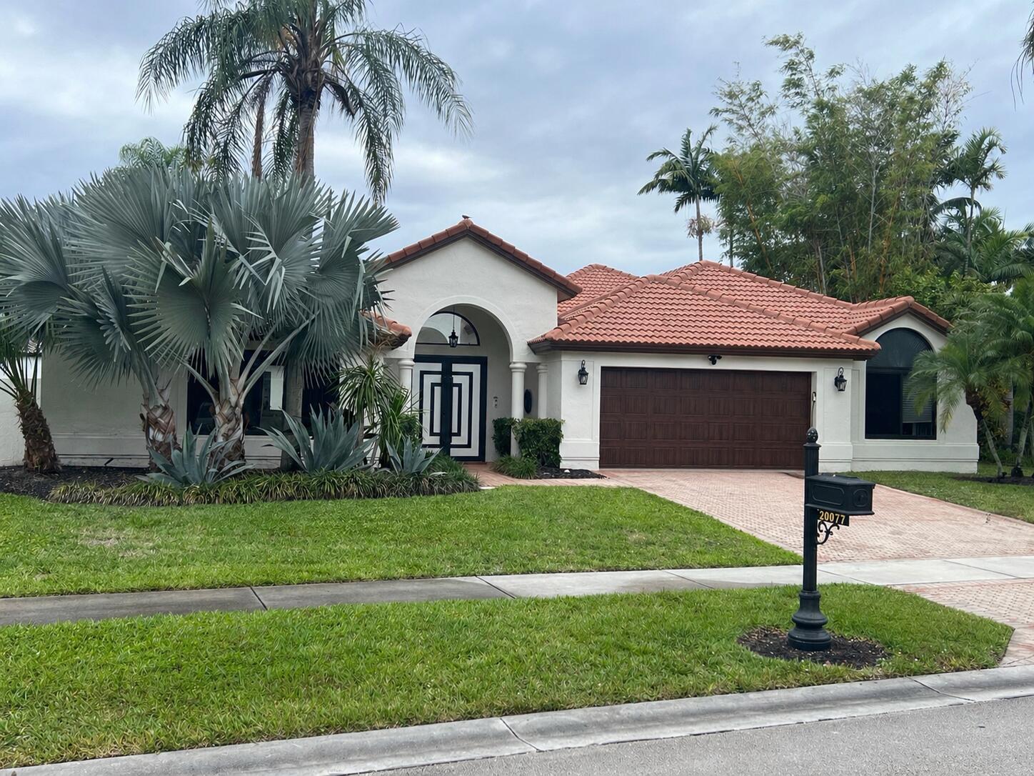 20077 Palm Island Drive Boca Raton, FL 33498 - Photo 2 of 47 a front view of a house with a yard and garage