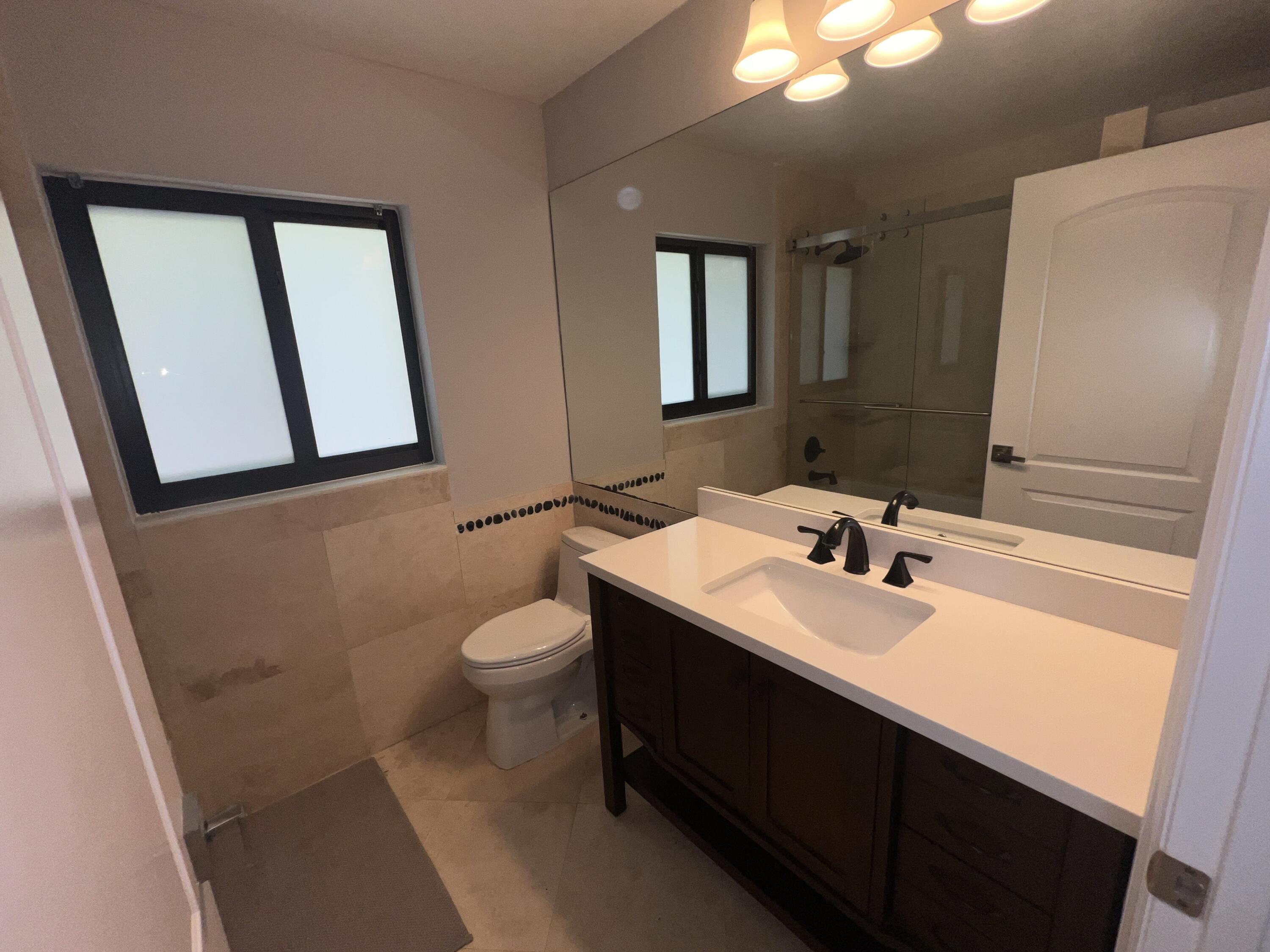 20077 Palm Island Drive Boca Raton, FL 33498 - Photo 30 of 47 a bathroom with a toilet sink and mirror