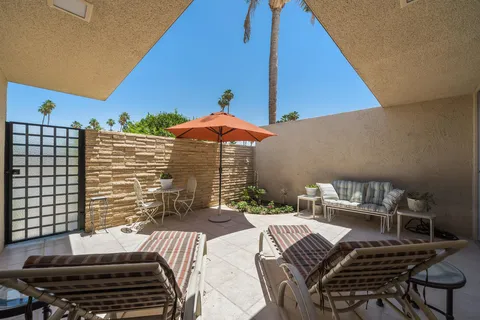 a backyard of a house with table and chairs