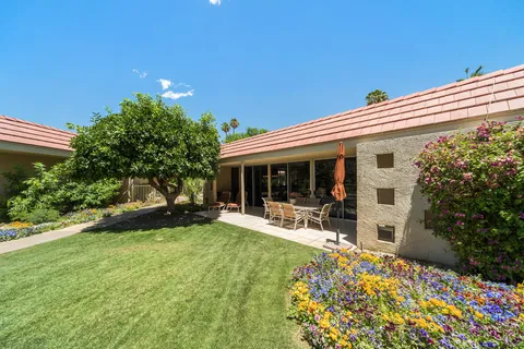 a view of a patio with table and chairs and a large tree