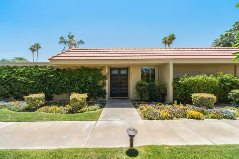 a view of a swimming pool with a garden and a table