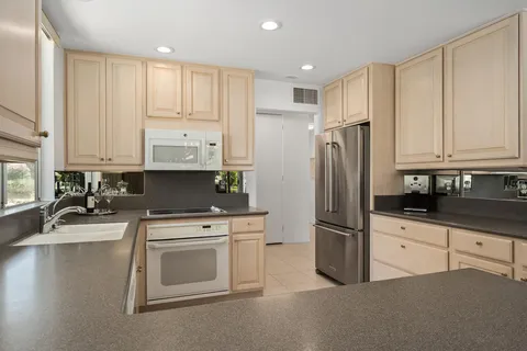 a kitchen with stainless steel appliances granite countertop a refrigerator sink and cabinets