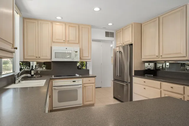 a kitchen with stainless steel appliances granite countertop a refrigerator sink and cabinets