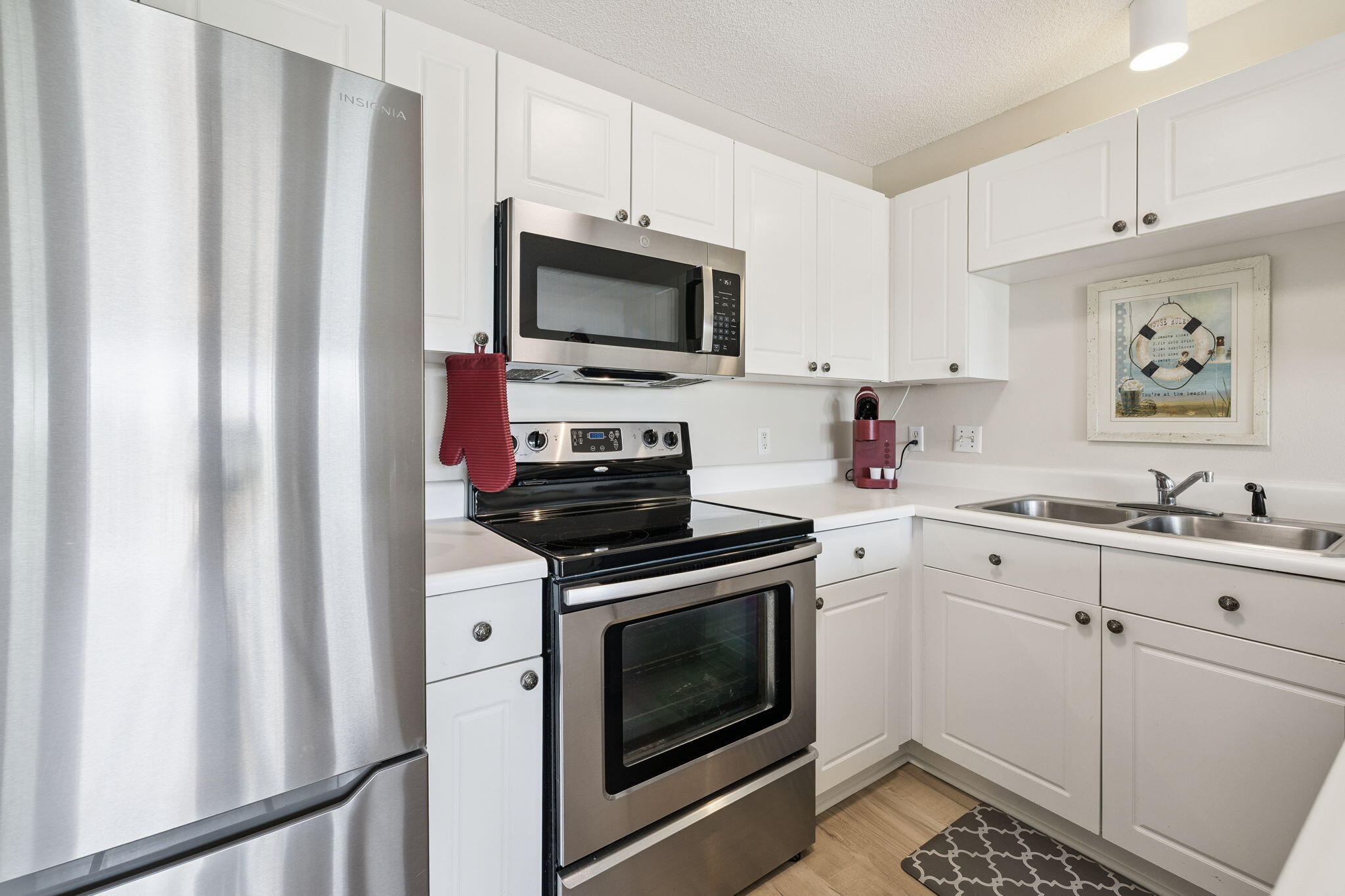 144 Spires Lane, Unit 310 Santa Rosa Beach, FL 32459 - Photo 17 of 41 a kitchen with white cabinets stainless steel appliances and sink