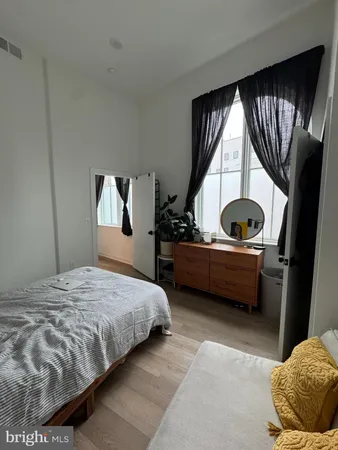 a bedroom with a bed and wooden floor