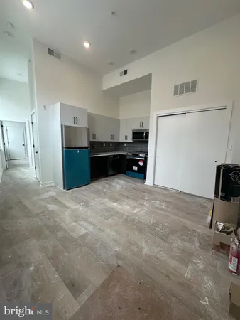 a kitchen with kitchen island a stove a refrigerator and a sink with wooden floor