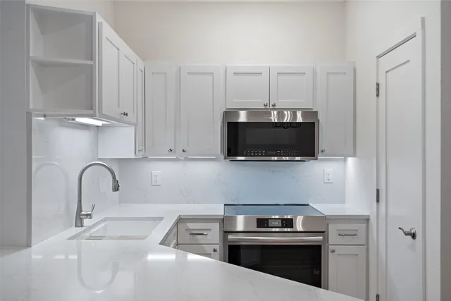a kitchen with a sink and a stove top oven