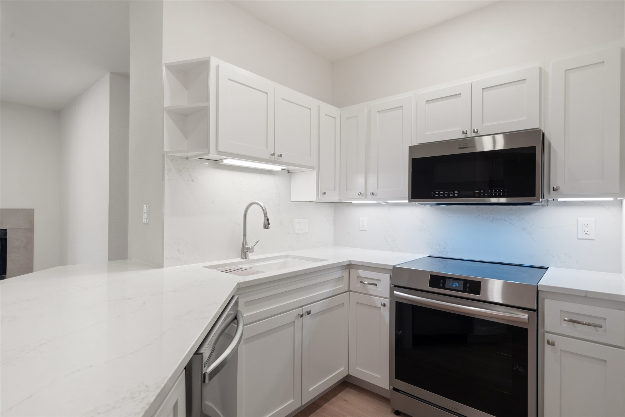 2450 Wickersham Lane, Unit 1307 Austin, TX 78741 - Photo 6 of 20 Kitchen with a sink, open shelves, light stone countertops, stainless steel appliances, and decorative backsplash